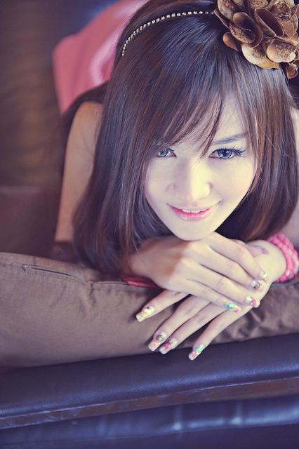 Junge Thailänderin liegend mit lackierten Fingernnägeln